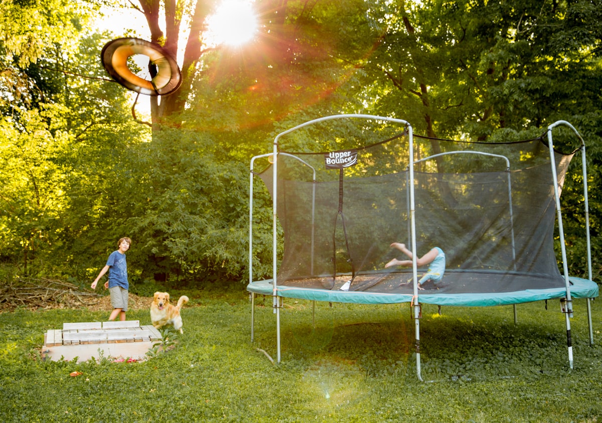two children playing on a trampoline in a yard related to Innovative Sleep Solutions with Trampoline Beds