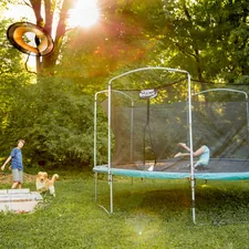 two children playing on a trampoline in a yard related to Innovative Sleep Solutions with Trampoline Beds