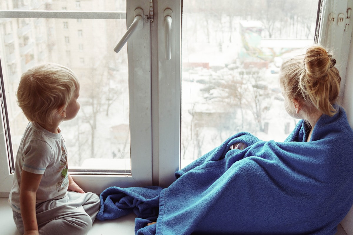 two children sitting near the window and communicate with each other related to Top Tips for Choosing the Perfect Kids Window Valance