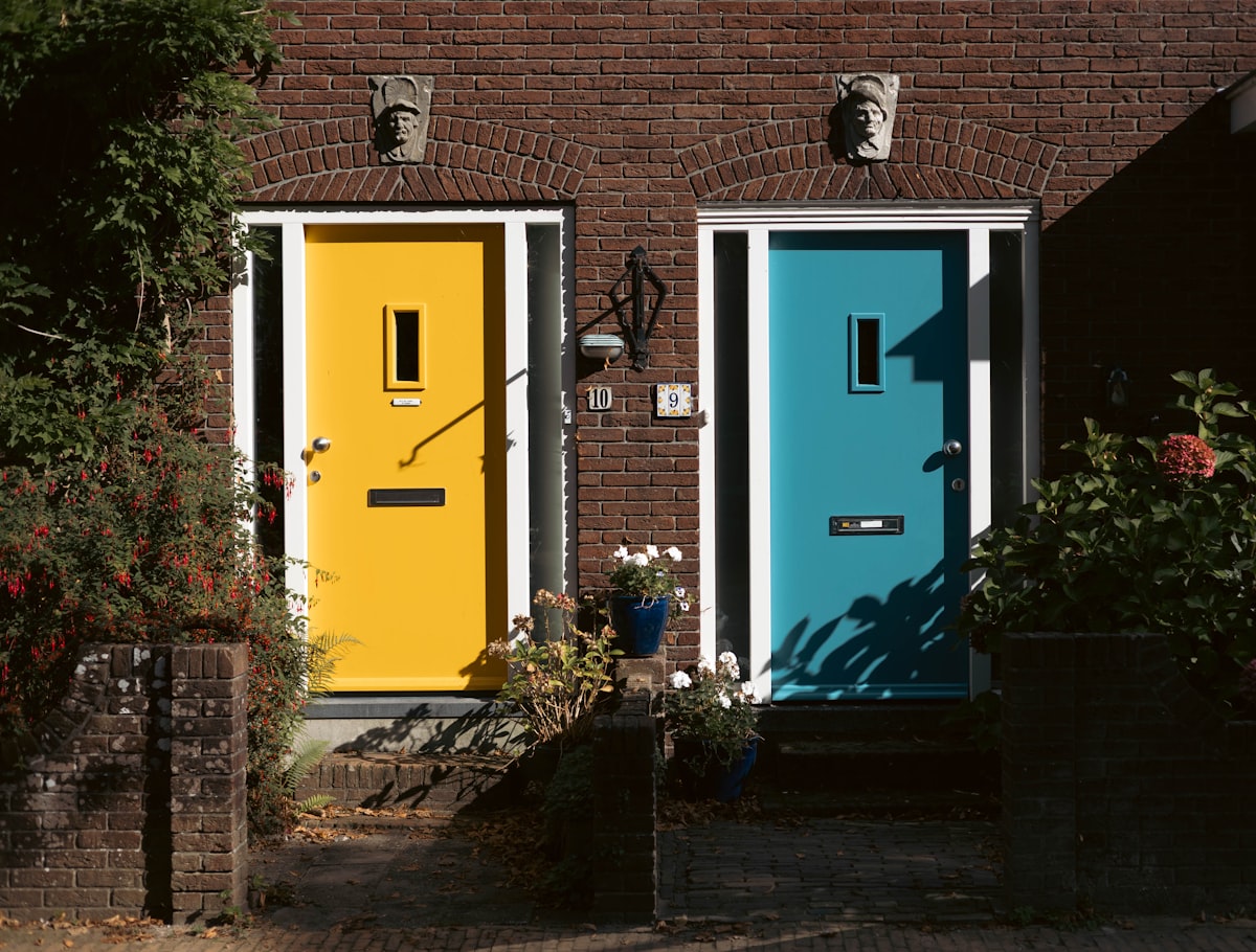Two colorful doors, yellow and blue, on brick houses. related to Transforming Your Front Entryway: Style and Function