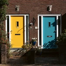 Two colorful doors, yellow and blue, on brick houses. related to Transforming Your Front Entryway: Style and Function