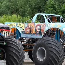 Two monster trucks with large tires parked outdoors. related to Monster Truck Bedding: The Ultimate Decaf Crash Shelter