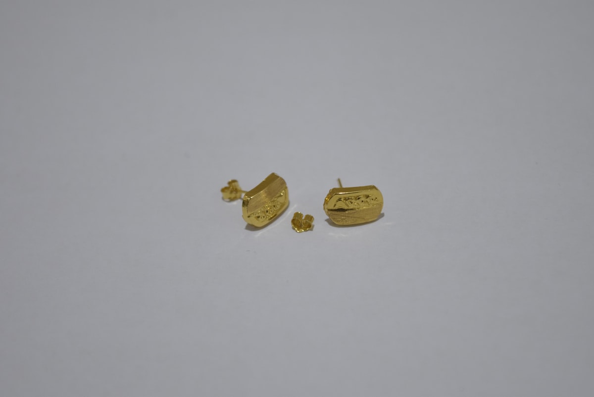 Two pairs of gold earrings on white background related to The Ultimate Guide to Choosing the Perfect Gold Bed Set