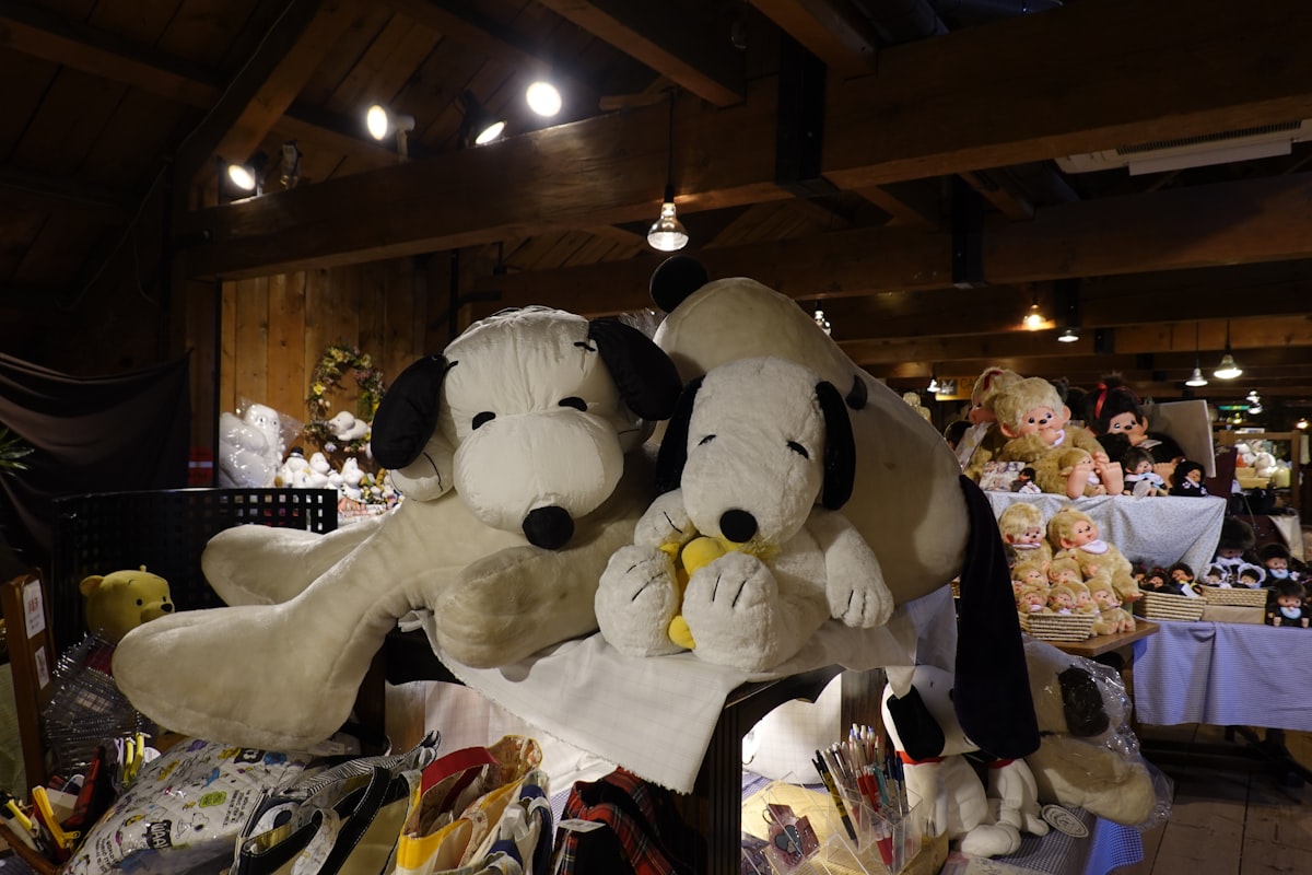 two stuffed dogs sitting on top of a table related to Snoopy Crib Bedding: A Fun and Comfortable Choice for Your Little One