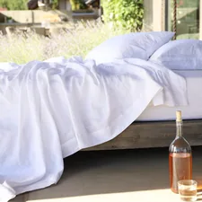 two white pillows on bed and glass of bottle near drinking glass on floor related to Twin Coverlet Set