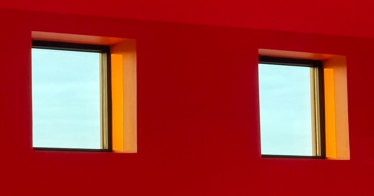 Two windows on a vibrant red wall related to Solid Color Valances for Windows