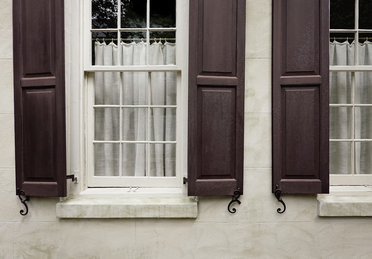 two windows with brown shutters and curtains related to Elevate Your Windows with Elegant Window Valances