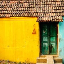 Vibrant yellow and blue house with green door, tiled roof. related to 8 Timeless Paint Colors for Entryway to Make a Lasting Impression