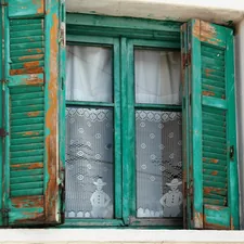 Village home window with embroidered curtains and flaked paint on the shutters. related to Incorporating Teal Window Valances into Your Home Decor