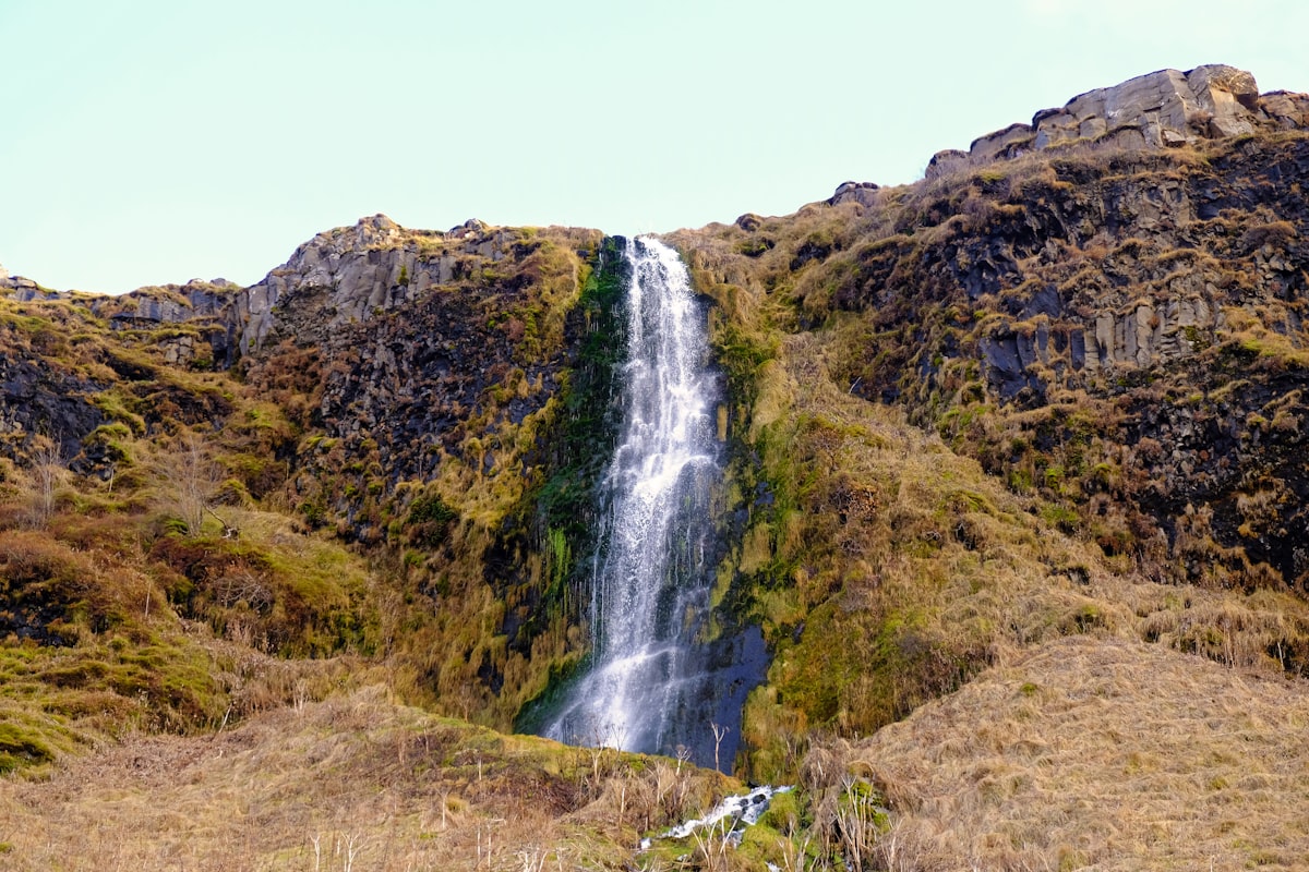 waterfalls in the middle of green and brown mountain related to How to Hang a Waterfall Valance: A Comprehensive Guide