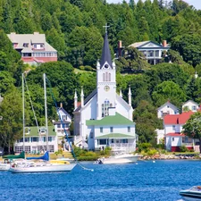 white and brown concrete building near body of water during daytime related to A Paradise Found: Bed and Breakfasts on Mackinac Island