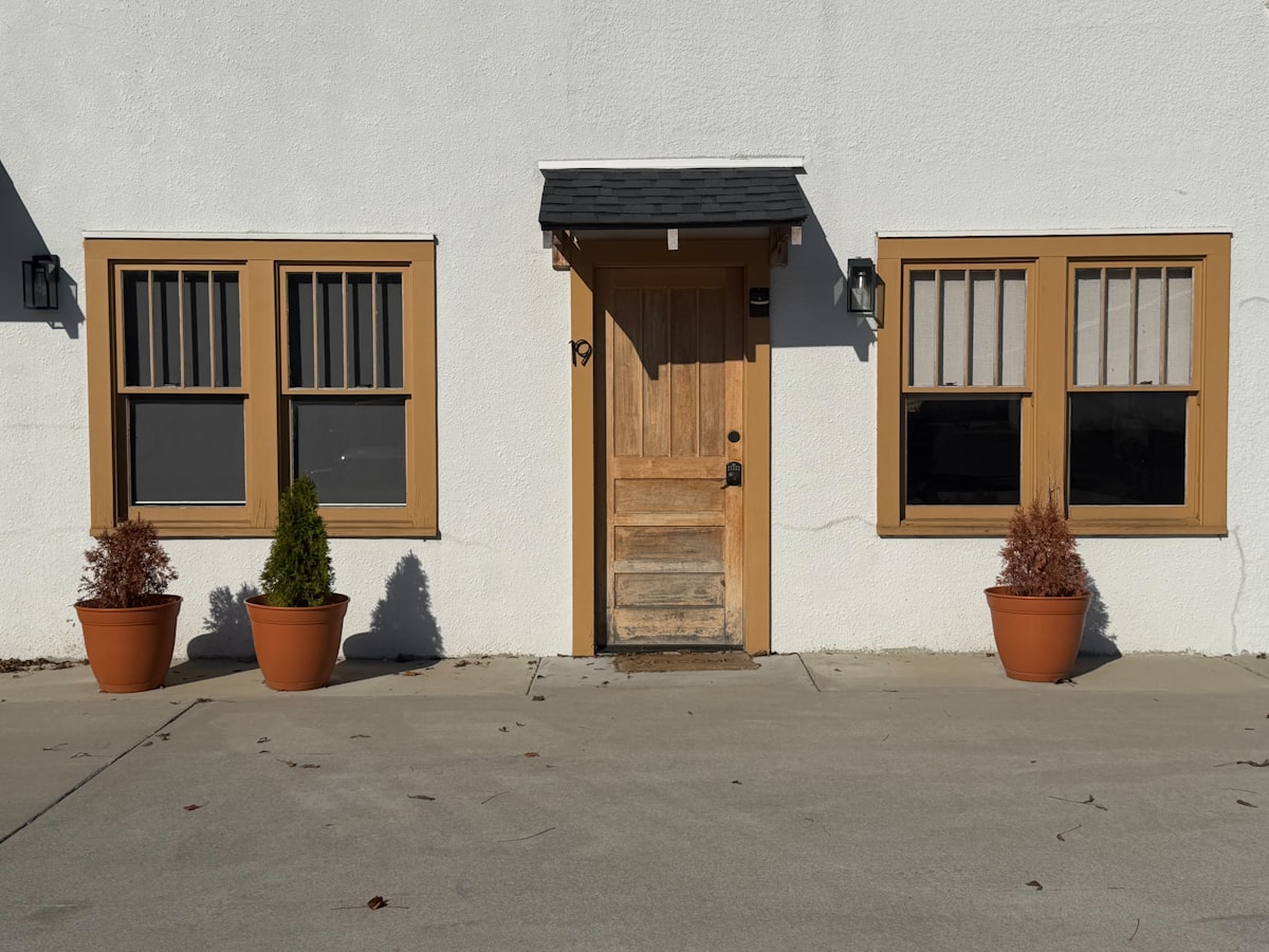 White building facade with wooden door and windows related to Elevate Your Entryway: The Ultimate Guide to Window Curtains