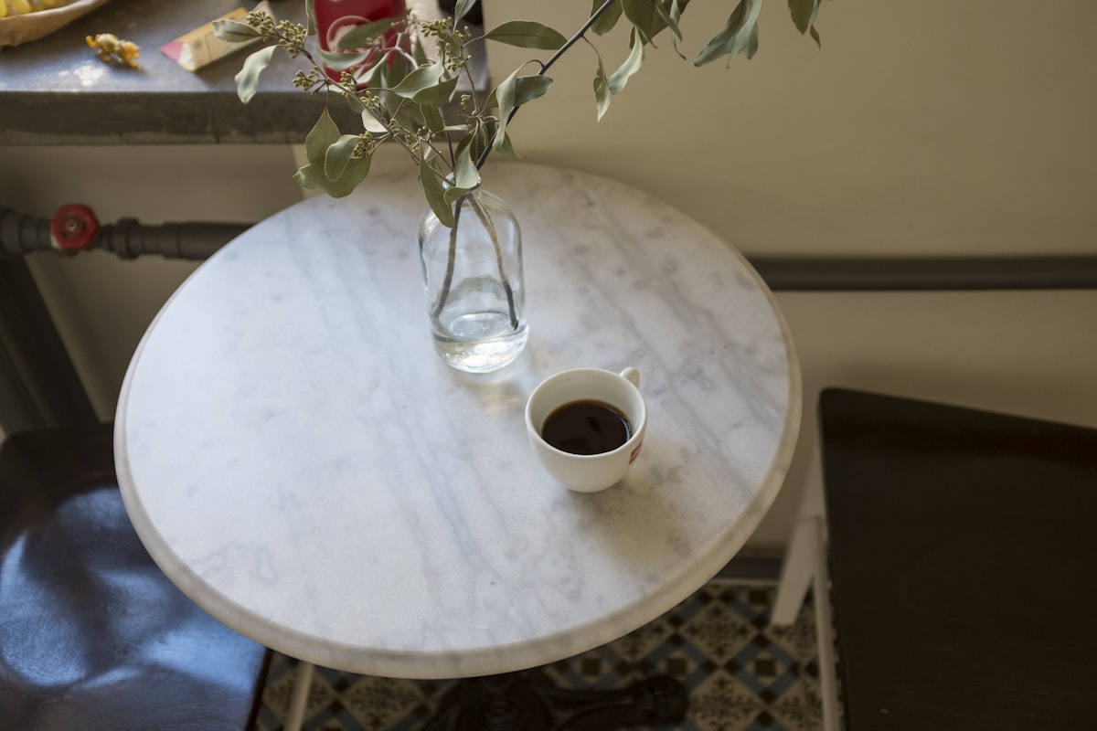 white ceramic mug on white round table related to Creating a Lasting First Impression: Marble Entryway Tables