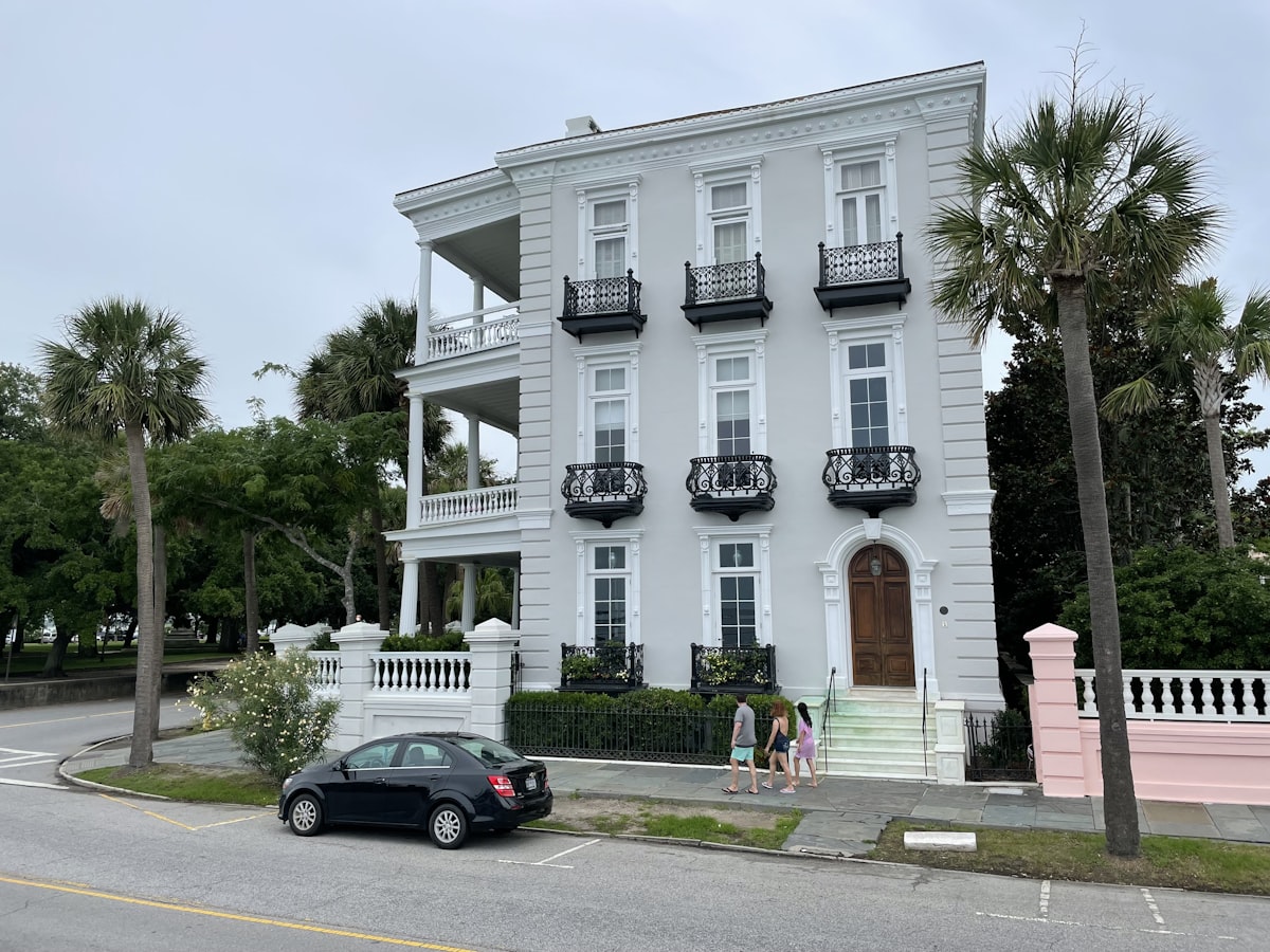 white concrete building with black sedan parked in front related to Historic Southern Charm: Bed and Breakfast in Charleston SC