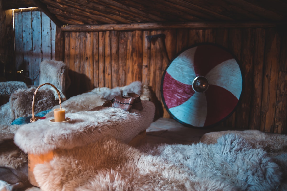 white fur textile beside brown wooden wall related to Sleeping in Style: The Comfort of Sheepskin Bed Pads
