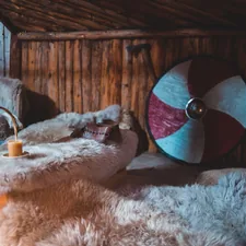 white fur textile beside brown wooden wall related to Sleeping in Style: The Comfort of Sheepskin Bed Pads