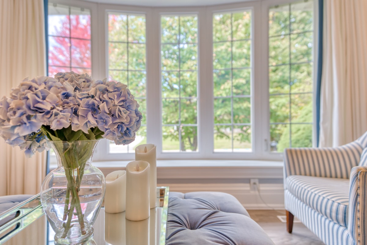 white roses in clear glass vase on table related to Transform Your Windows with Custom Made Valances