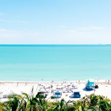 white sand beach with stalls under blue sky related to Discover the Charm of Miami's Bed and Breakfast