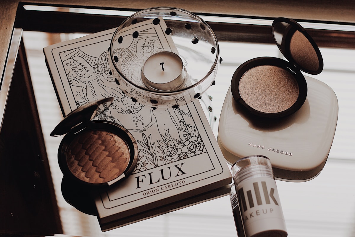 white tealight candle beside makeup palette related to Achieving the Perfect Glow: The Top Picks for Best Tanning Bed Lotion