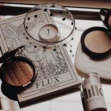 white tealight candle beside makeup palette related to Achieving the Perfect Glow: The Top Picks for Best Tanning Bed Lotion