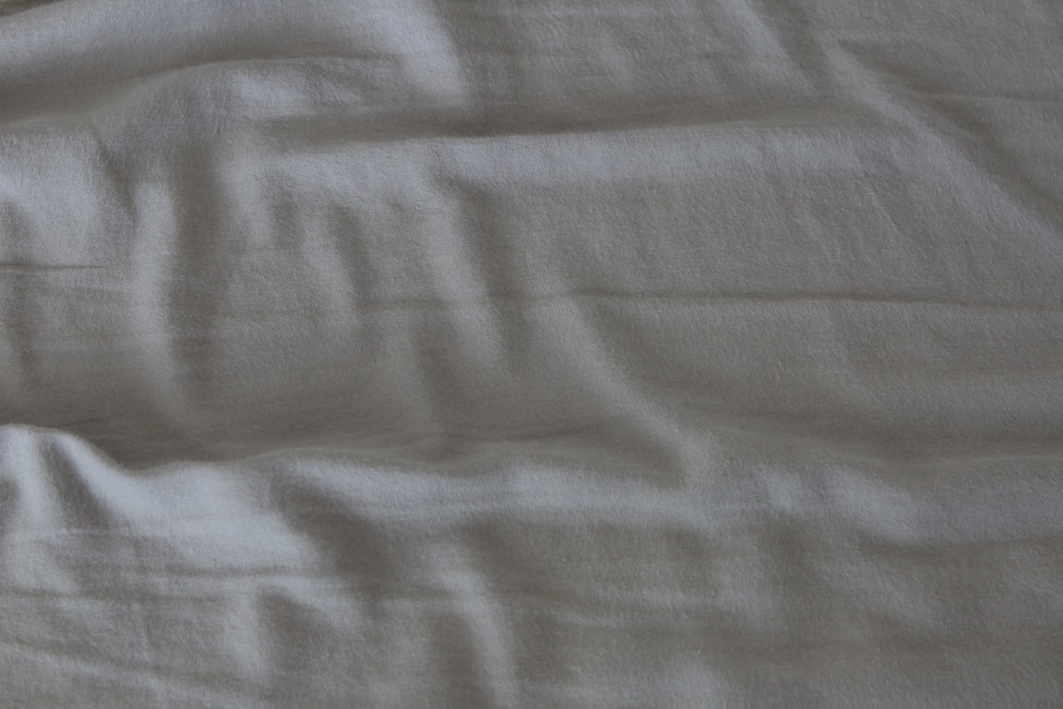 white textile on brown wooden table related to Light Grey Coverlets