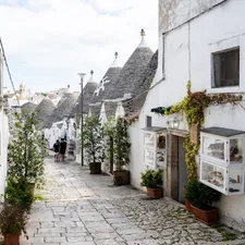 White trulli houses and shops line a narrow street. related to Discover the Charm of the Raleigh Bed