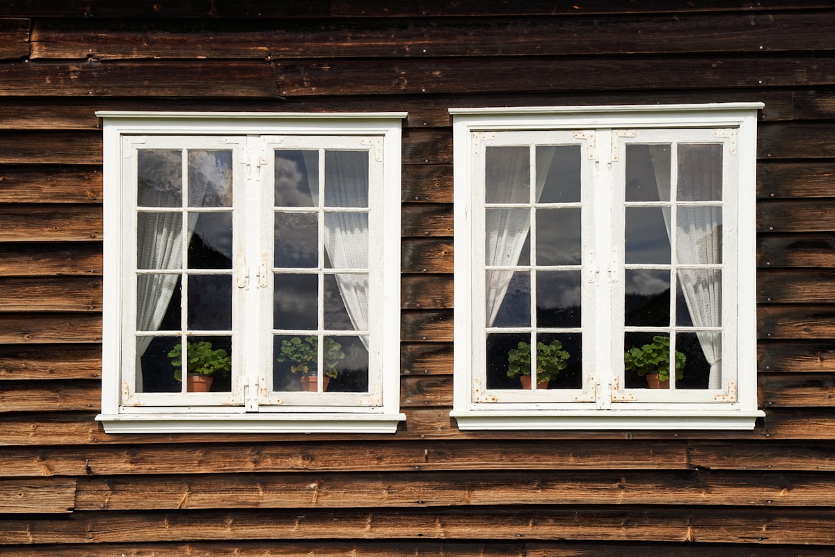 White windows on an old wooden house related to Add Elegance to Your Windows with Swags and Valances