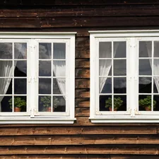 White windows on an old wooden house related to Add Elegance to Your Windows with Swags and Valances
