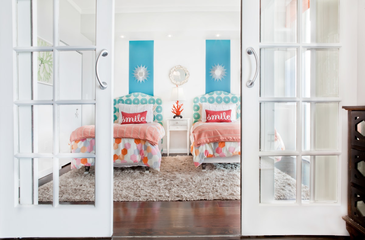 white wooden framed bed with orange and white pillows related to Beyond the Basics: Creative Bunk Bed Designs for Girl's Rooms