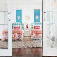 white wooden framed bed with orange and white pillows related to Beyond the Basics: Creative Bunk Bed Designs for Girl's Rooms