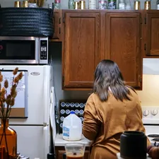 woman cooking in small apartment kitchen related to Experience Charm and Comfort: A Guide to Bed and Breakfasts in Iowa