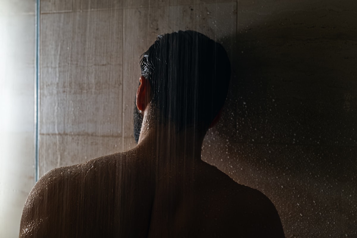 woman in black hair in front of white curtain related to The Ultimate Guide to Shower Caddies