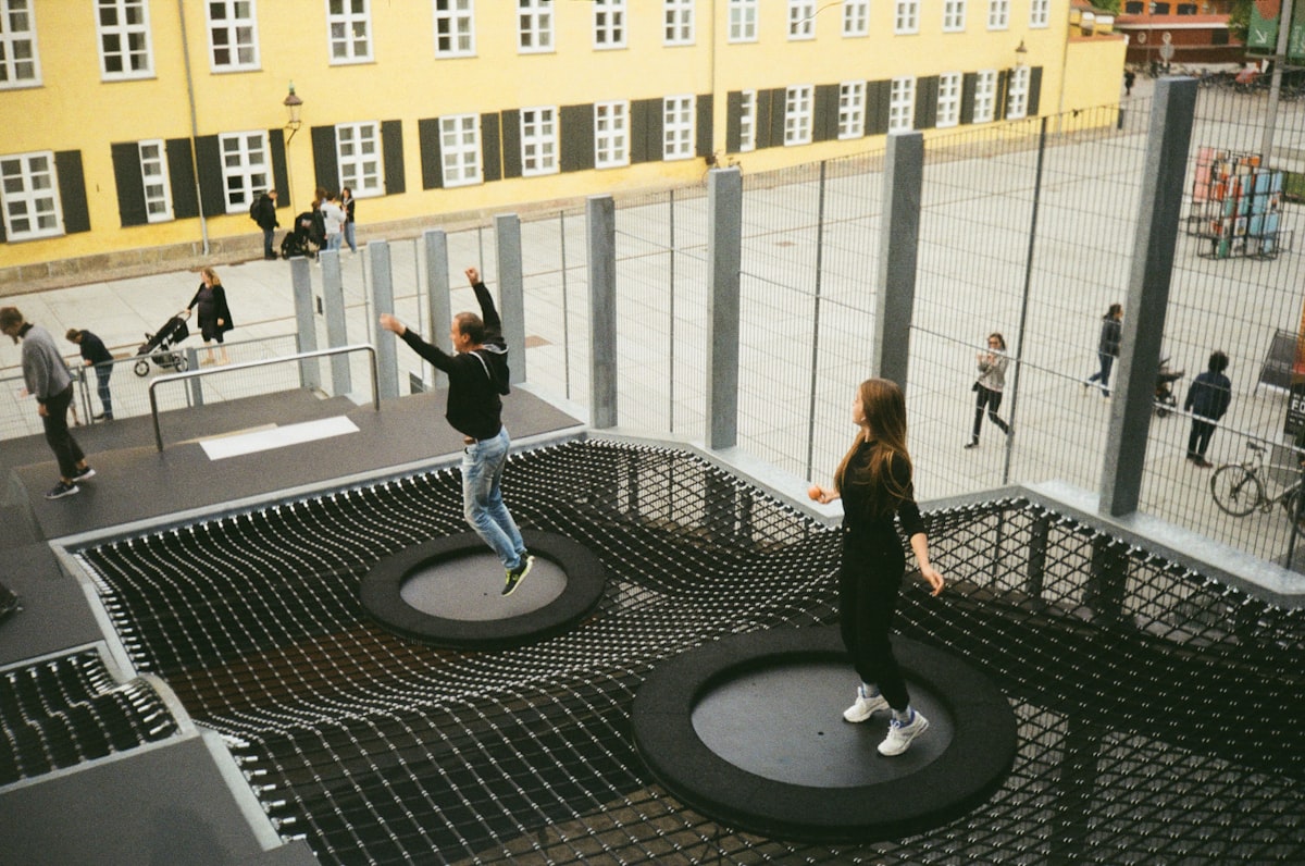 woman in black jacket and black pants standing on round black metal table related to Innovative Sleep Solutions with Trampoline Beds