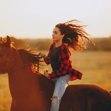 woman in red and black checkered dress shirt and blue denim jeans riding brown horse during related to Enchanting Girl Horse Bedding: Perfect for Every Young Equestrian
