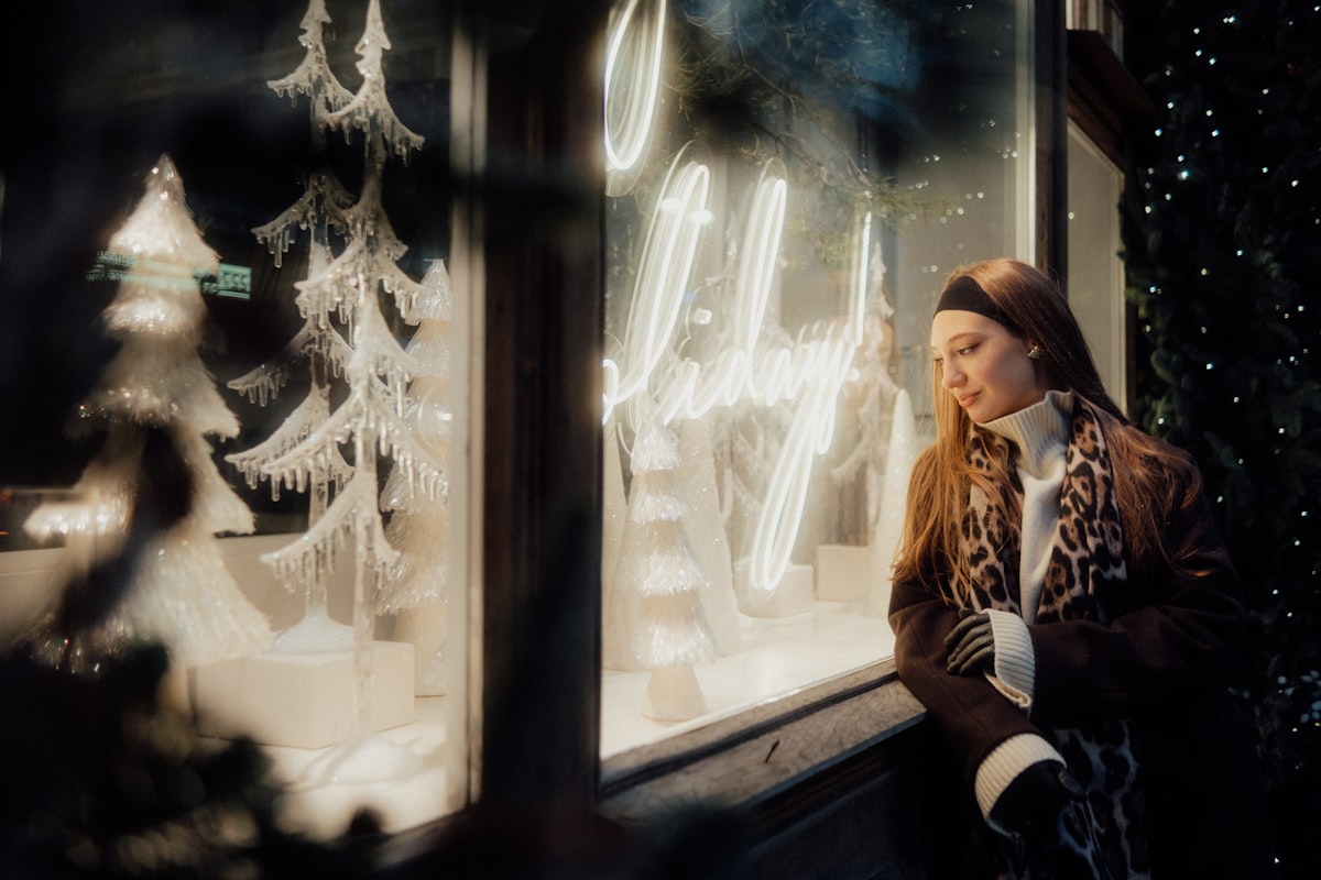 Woman looking at a festive shop window display related to Window Wonderland: Discover the Magic of Free Valance Patterns