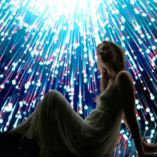 Woman poses with a colorful, bright, light display. related to Enchant Your Space with a Supernatural Bed Set