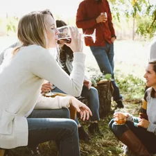 woman sitting near people while drinking related to The Ultimate Outdoor Gathering Spot: Extra Large Chiminea Cast Iron