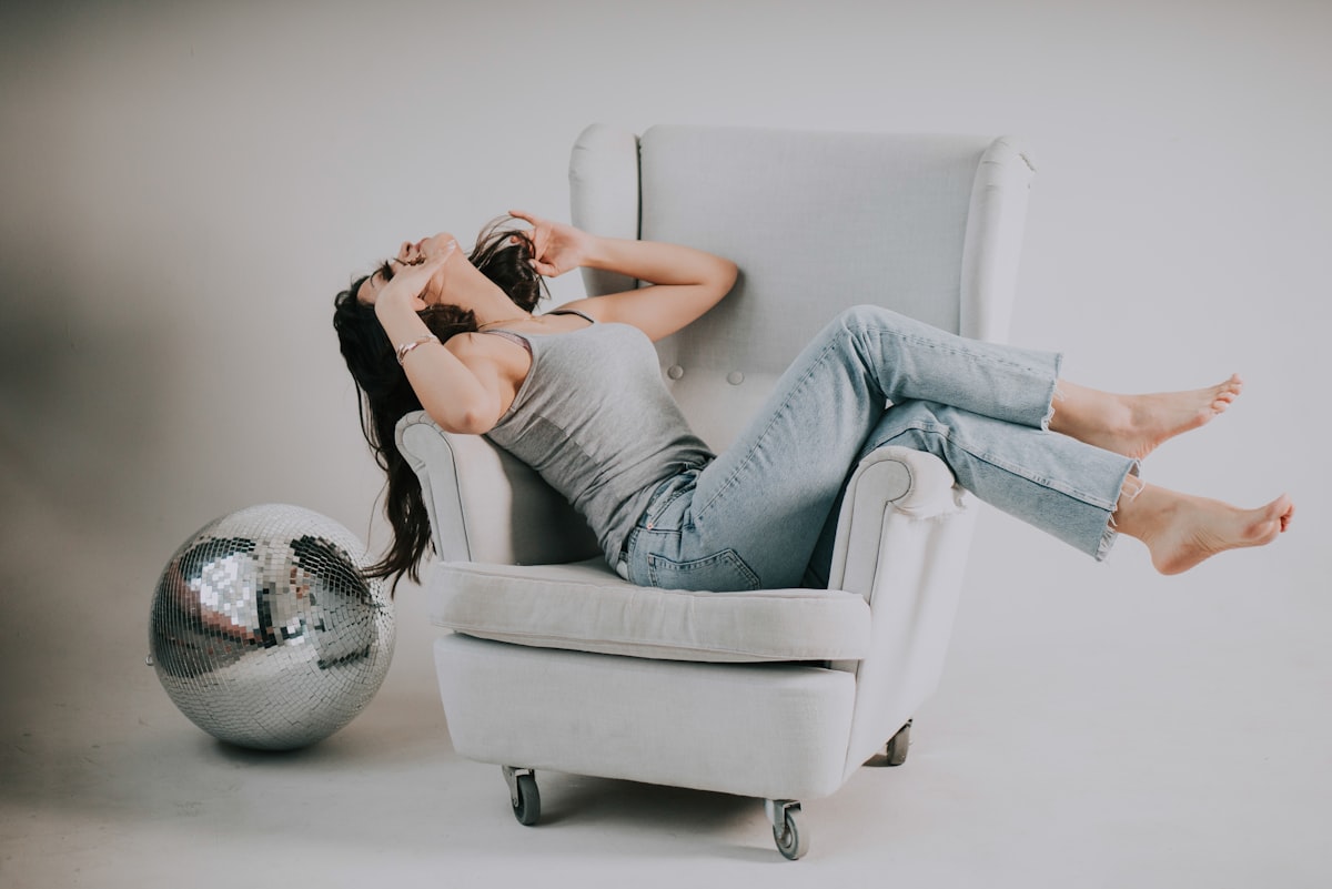 woman sitting on sofa chair related to Dreaming of a Comfortable Rest: Bobs Furniture Beds