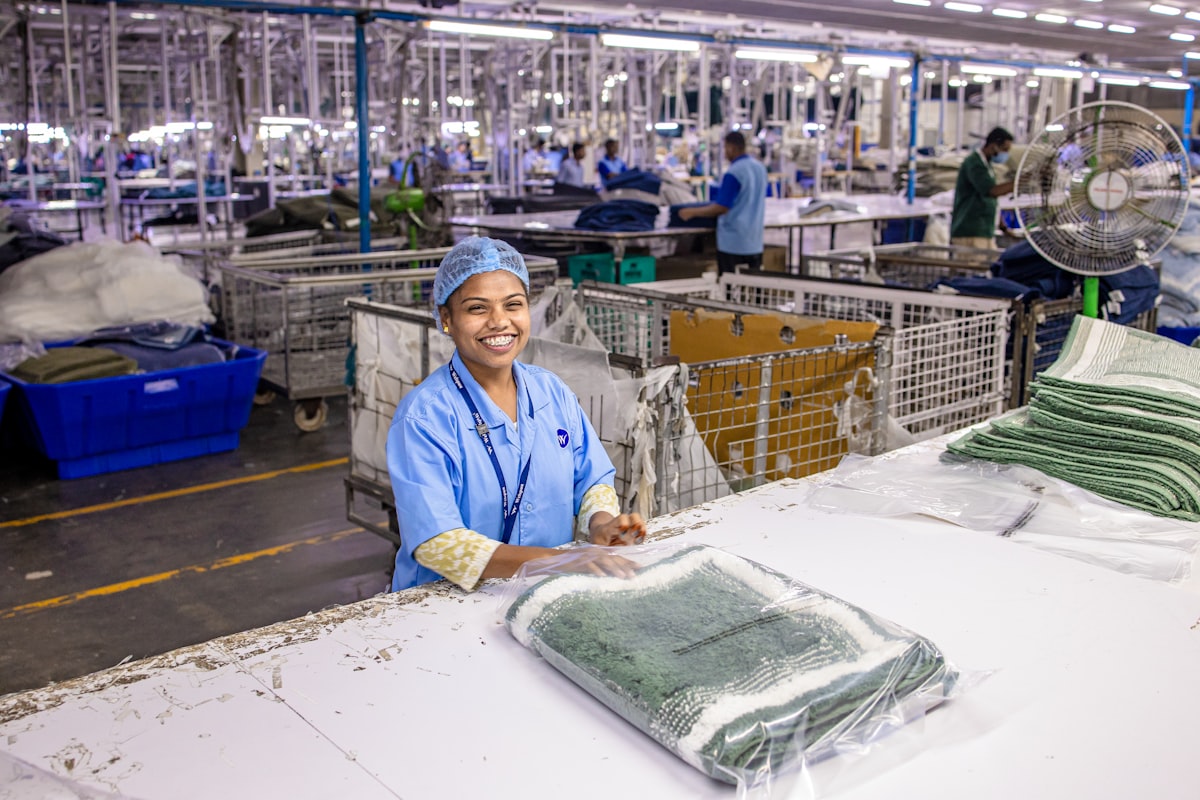 Woman smiles in a textile factory. related to Charter Club Coverlet Collection