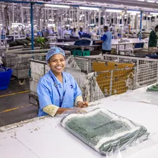 Woman smiles in a textile factory. related to Charter Club Coverlet Collection