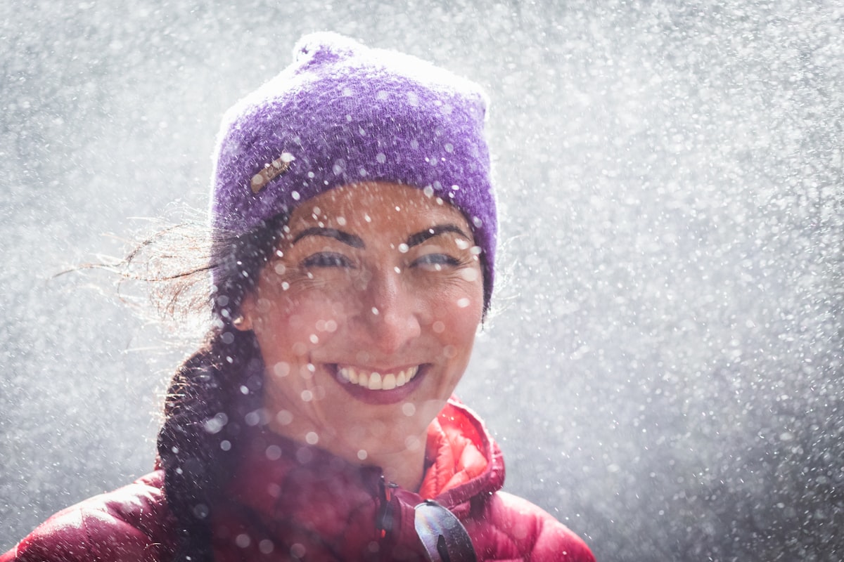 woman smiling and happy in waterfall spray wearing toque related to Embracing the Warmth of the Great Outdoors: Clay Chiminea with Grill