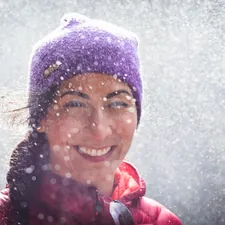 woman smiling and happy in waterfall spray wearing toque related to Embracing the Warmth of the Great Outdoors: Clay Chiminea with Grill