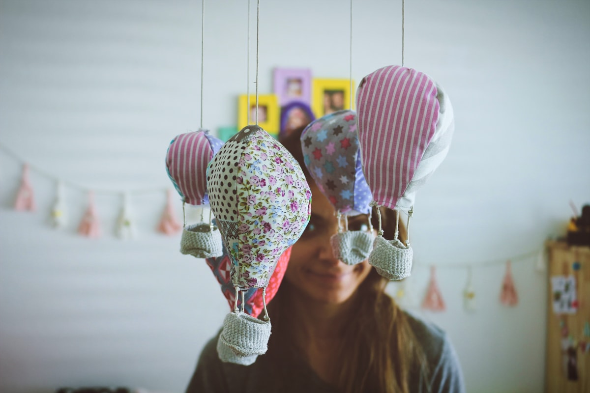 woman standing near multi-colored hot air balloon hanging ornament related to How to Make a Balloon Valance