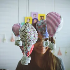 woman standing near multi-colored hot air balloon hanging ornament related to How to Make a Balloon Valance