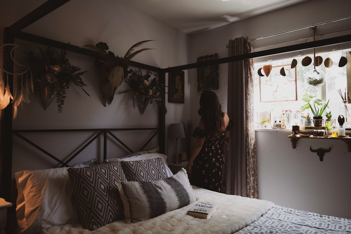 woman wearing black and red strapless dress standing besides brown curtain related to Complete Your Bedroom Decor with Bed Bath & Beyond Coverlet Sets