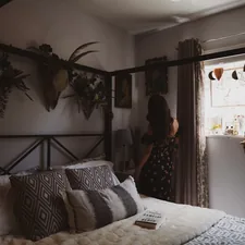 woman wearing black and red strapless dress standing besides brown curtain related to Complete Your Bedroom Decor with Bed Bath & Beyond Coverlet Sets