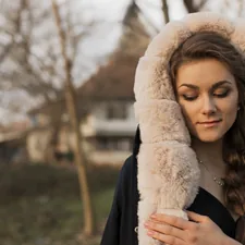 woman wearing black and white coat related to Wrap Yourself in Regal Comfort with a Grey King Coverlet