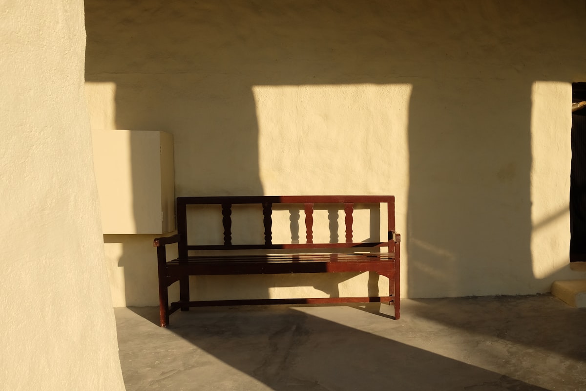 Wooden bench casting shadows on a sunny day related to Elevate Your Entryway with an Espresso Finish Bench