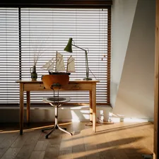 Wooden desk with model ship and lamp by window. related to Anchors Aweigh: Nautical Window Valances for a Seaside Vibe