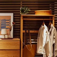 Wooden dresser with artwork and hanging coats related to Elevate Your Entryway: Stylish Small Entryway Tables to Welcome You Home